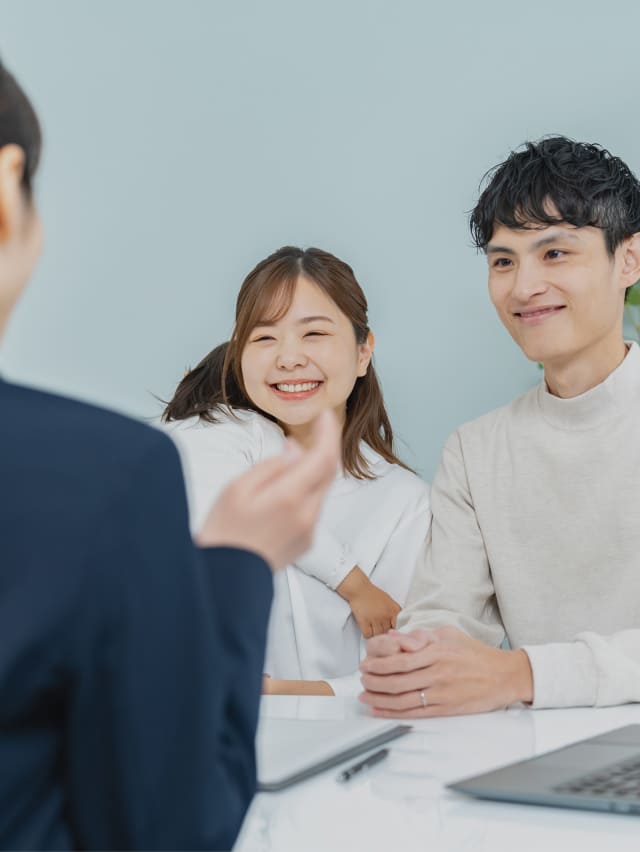 夫婦と子どもが会社員と話をしている写真